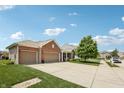 Brick and vinyl sided home with large three car garage and front yard at 8855 Banner Dr, Brownsburg, IN 46112