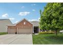 Traditional brick home with an attached three car garage and covered front porch at 8855 Banner Dr, Brownsburg, IN 46112