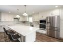 Bright kitchen boasts stainless steel appliances, white cabinetry, a large island, and hard surface countertops at 996 Denton Ct, Westfield, IN 46074