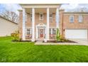 Inviting brick home with white columns, benches on the front porch, and a well-manicured lawn at 10090 Eagle Eye Way, Indianapolis, IN 46234