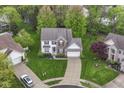 Expansive aerial view of a suburban home with lush green lawn, mature trees, and a private driveway at 10524 Hawks Ridge Ct, Fishers, IN 46037