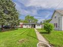 Landscaped front yard leading to a charming home featuring mature trees and a well-manicured lawn at 108 W Cross St, Anderson, IN 46012