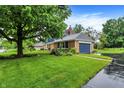 Beautiful home with an attached garage, surrounded by a well-maintained lawn and mature trees at 1095 Williamsburg Ln, Zionsville, IN 46077