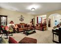 Cozy living room with comfortable sofas, a rocking chair, lamps, and neutral colored walls at 1141 Lazio Ct, Greenwood, IN 46143