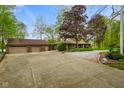 Expansive driveway leading to a brick home with a detached garage, offering ample parking space at 12142 N Paddock Rd, Camby, IN 46113