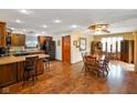 Open kitchen and dining area with wooden cabinetry, stainless steel appliances, and hardwood floors at 12142 N Paddock Rd, Camby, IN 46113