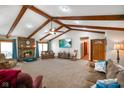 Inviting living room with vaulted ceilings, wooden beams, brick fireplace and a large tv at 12142 N Paddock Rd, Camby, IN 46113