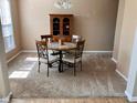 Cozy dining room features neutral carpet, wood table with four chairs, and a classic china cabinet at 13766 Heatherfield Dr, Fishers, IN 46038
