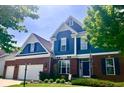Beautiful two-story home with brick and blue siding, well-manicured landscaping and a welcoming front porch at 13766 Heatherfield Dr, Fishers, IN 46038