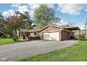 View of well maintained single Gathering home with a two car attached garage and drive way at 1416 Wellington Ave, Indianapolis, IN 46219