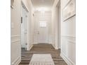 Bright and airy hallway with hardwood floors and elegant white wainscoting at 14878 Anees Ln, Fishers, IN 46040