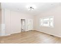 Bright, neutral living space with wood floors, white trim, and an open floor plan with a modern light fixture at 1523 S K St, Elwood, IN 46036