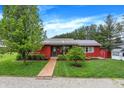 Charming single-story home with vibrant red siding, metal roof and mature landscaping at 1630 N 400 W, Bargersville, IN 46106