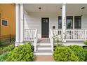 Close up of the white front porch with black front door and well manicured landscaping at 2044 Alvord St, Indianapolis, IN 46202
