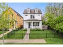 Charming white home with black fence, landscaped front yard, and welcoming curb appeal at 2044 Alvord St, Indianapolis, IN 46202
