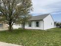 A charming one-story house with light green shutters and a blooming tree in the front yard at 3019 Knobstone Ln, Indianapolis, IN 46203