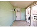 Covered porch features wooden floors, painted railings, and a paneled front door with sidelight at 474 N Randolph St, Indianapolis, IN 46201