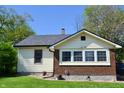 Charming home with tan siding, brick foundation, and a well-maintained lawn at 480 E Walnut St, Martinsville, IN 46151