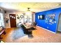 Bright living room with a blue accent wall, plush seating, and a ceiling fan at 480 E Walnut St, Martinsville, IN 46151