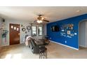 Cozy living room featuring neutral carpet, a ceiling fan, and accent wall at 480 E Walnut St, Martinsville, IN 46151