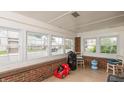 Bright sunroom with multiple windows, brick accents and light tile floors at 480 E Walnut St, Martinsville, IN 46151