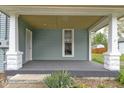 Covered front porch with a door, small window, white pillars and gray painted porch floor at 524 S State St, Greenfield, IN 46140