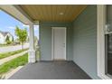 Covered front porch with a door, white pillars, and gray painted porch floor at 524 S State St, Greenfield, IN 46140