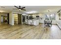 Open-concept kitchen with white cabinets, stainless steel appliances, large island, and wood-look flooring at 5707 S Burlington Dr, Muncie, IN 47302