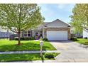 Charming single-story home with a manicured lawn, a stone facade, and an attached two-car garage at 5809 Scotland St, Indianapolis, IN 46234