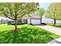 Charming single-story home with a manicured lawn, a stone facade, and an attached two-car garage at 5809 Scotland St, Indianapolis, IN 46234