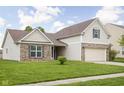 Side view of a well-maintained, two-story home with a manicured lawn and a two-car garage on a sunny day at 5864 Mustang Ter, Plainfield, IN 46168