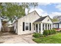 Cozy home with bright siding, black shutters, a sunroom, well-maintained landscaping, and a lush front lawn at 6167 Ralston Ave, Indianapolis, IN 46220
