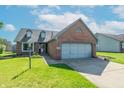 Charming brick home with a two-car garage, dormer windows, and well-maintained lawn under a bright sky at 623 White Ash Trl, Mooresville, IN 46158