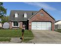 Charming brick home featuring a well-maintained lawn, attached garage, and inviting curb appeal at 623 White Ash Trl, Mooresville, IN 46158