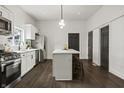 Modern kitchen with stainless steel appliances, a central island, and elegant dark-colored doors at 629 N Keystone Ave, Indianapolis, IN 46201