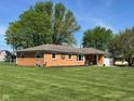 A well-maintained brick home with a tidy lawn, dark mulch beds, and mature trees at 630 Johnson Rd, Mooresville, IN 46158