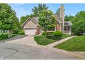 Charming single-story home with a well-manicured lawn, complemented by a two-car garage and mature trees at 65 Palomino Ct, Zionsville, IN 46077