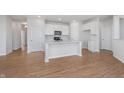 Well-lit kitchen features an island with a sink, white cabinets, and wood flooring at 6871 Seabiscuit Rd, Whitestown, IN 46075