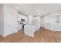 Open-concept kitchen features an island, white cabinets, and stainless steel appliances at 6871 Seabiscuit Rd, Whitestown, IN 46075