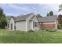 The back of this charming home is surrounded by a well-manicured lawn and mature trees at 7053 Colita More Nw Ct, Indianapolis, IN 46254