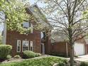 Charming red brick two-story home featuring a well-manicured lawn and mature shade trees at 7203 Sycamore Run Dr, Indianapolis, IN 46237