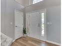 Bright foyer showcasing hardwood floors, a coat closet, and modern decor with plenty of natural light at 7203 Sycamore Run Dr, Indianapolis, IN 46237