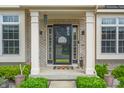 Welcoming front porch with black door and decorative details, flanked by windows at 7319 Hartington Pl, Indianapolis, IN 46259