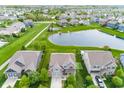 An aerial view of a beautiful two-story home by a pond with a well-maintained yard and driveway at 755 Canberra Blvd, Westfield, IN 46074