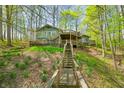 Multi-level deck wraps around the house nestled in a wooded setting, accessed by stairs from the hillside at 8277 N Lasalle Rd, Morgantown, IN 46160