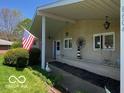 Charming covered front porch decorated with a lighthouse and an American flag at 8604 W Tulip Tree Dr, Muncie, IN 47304