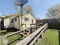 The backyard features a wooden deck with ramp, grassy area, and partial fencing at 907 W 14Th St, Muncie, IN 47302