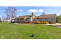 Inviting brick home with well-manicured lawn, mature landscaping, and a cozy front porch at 9377 N 500 W, McCordsville, IN 46055