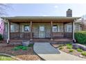 Charming covered porch with brick detailing, a seating bench, and a patterned welcome mat at 9377 N 500 W, McCordsville, IN 46055