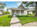 Attractive home with a welcoming front porch, complete with potted plants and manicured greenery at 1114 Pennsylvania St, Columbus, IN 47201